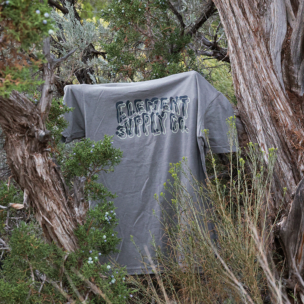 Grey Logo Tee hanging on branch